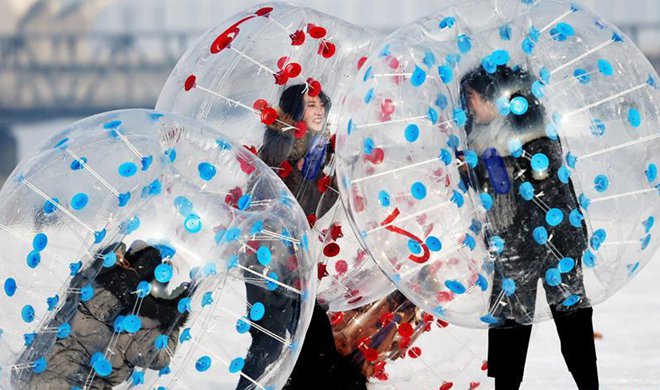 Tourists play on frozen Songhua River in NE China's Harbin