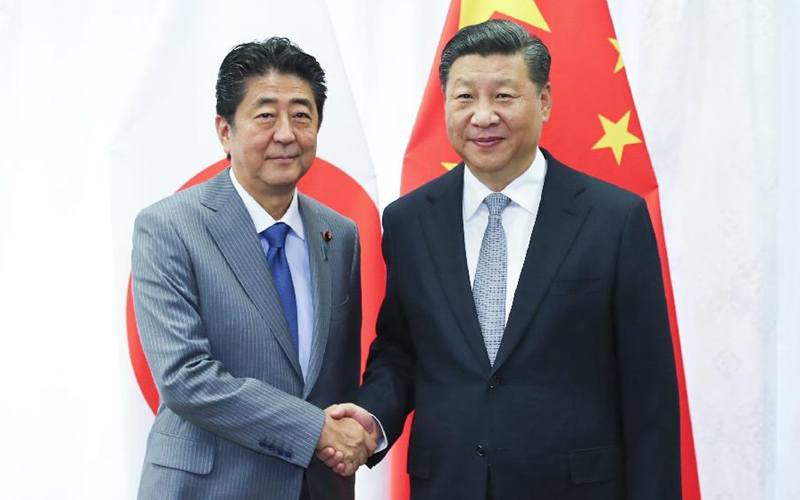 Xi, Abe meet on further improving China-Japan ties